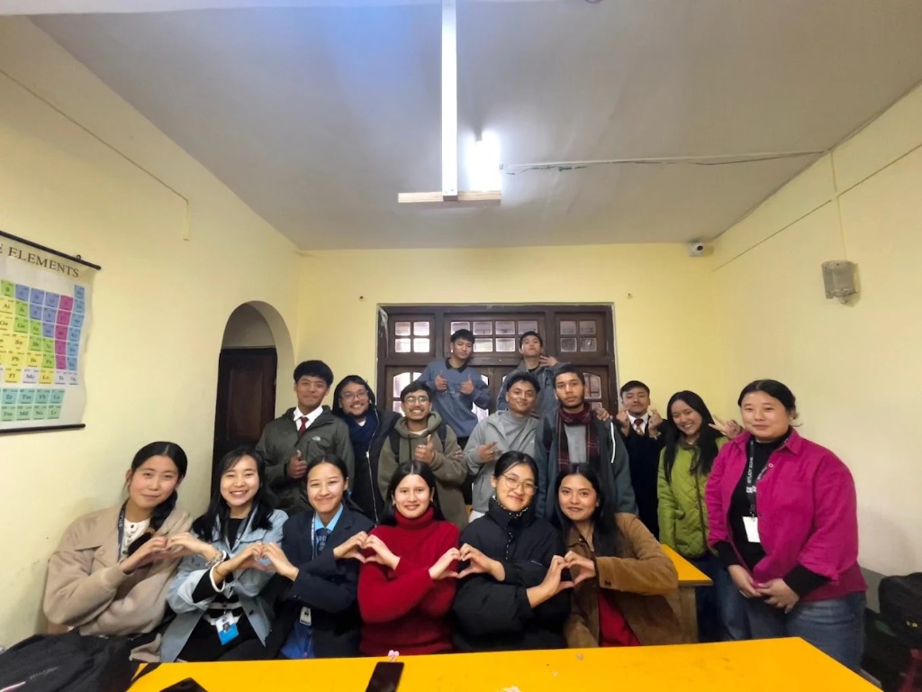 Students making heart signs together in the classroom